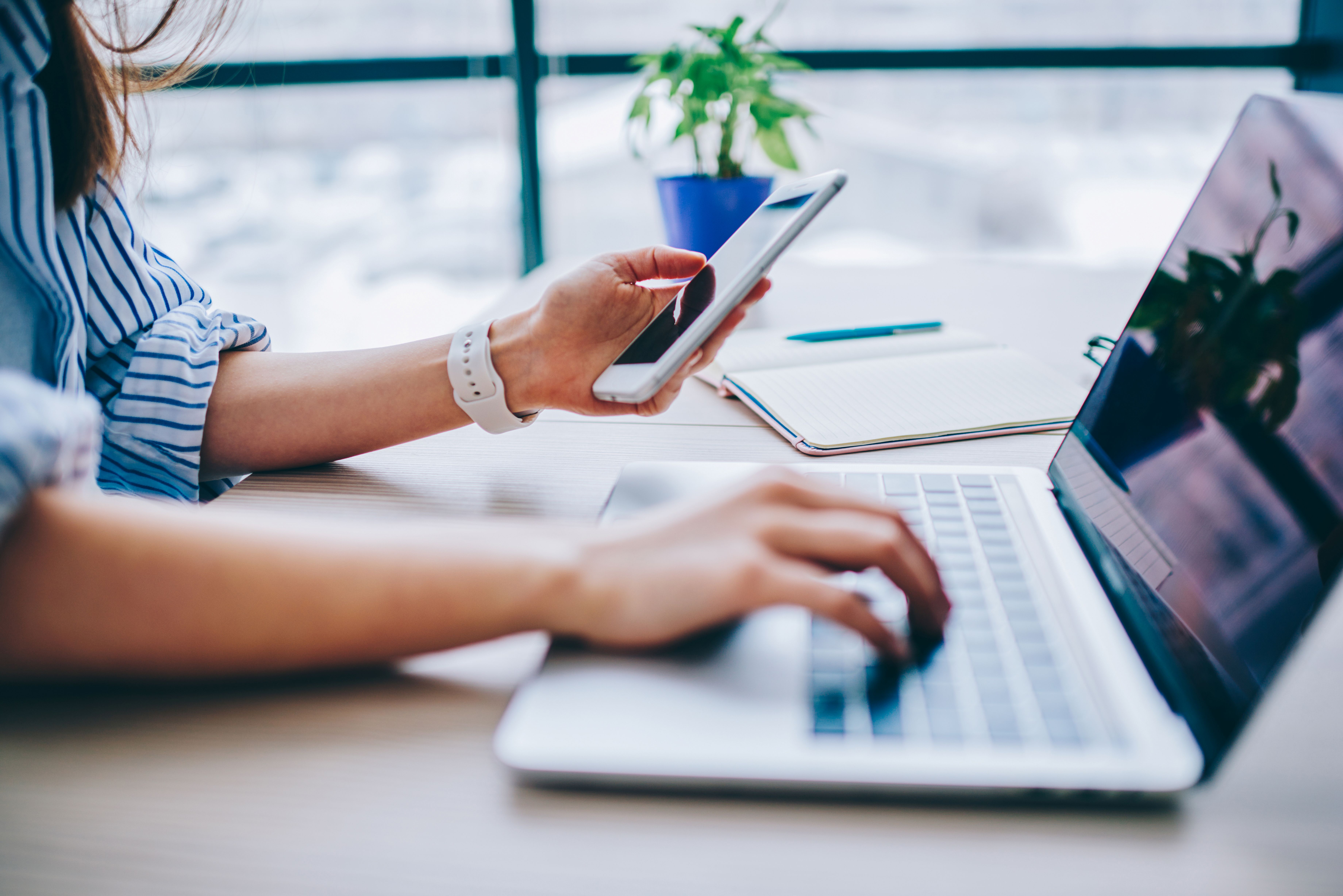Woman using a computer and mobile phone.
