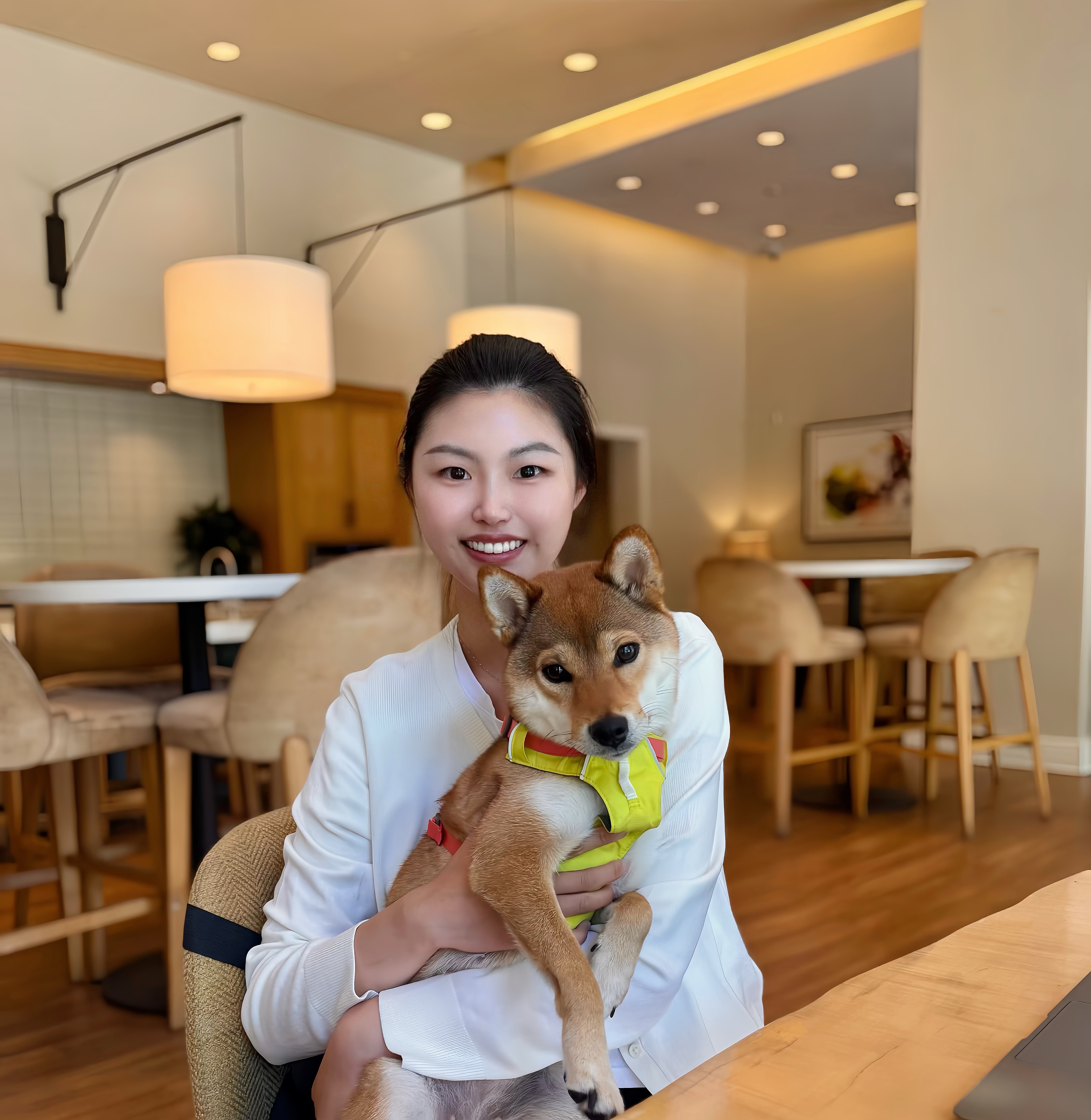 PhD student Benxi Zhang in a cafe holding her dog on her lap