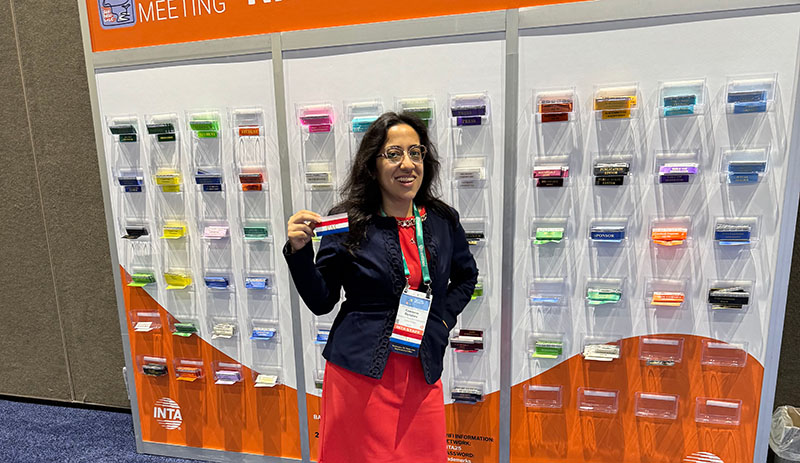 Czareena Dotchev in front of the INTA Annual Meeting Ribbon Wall
