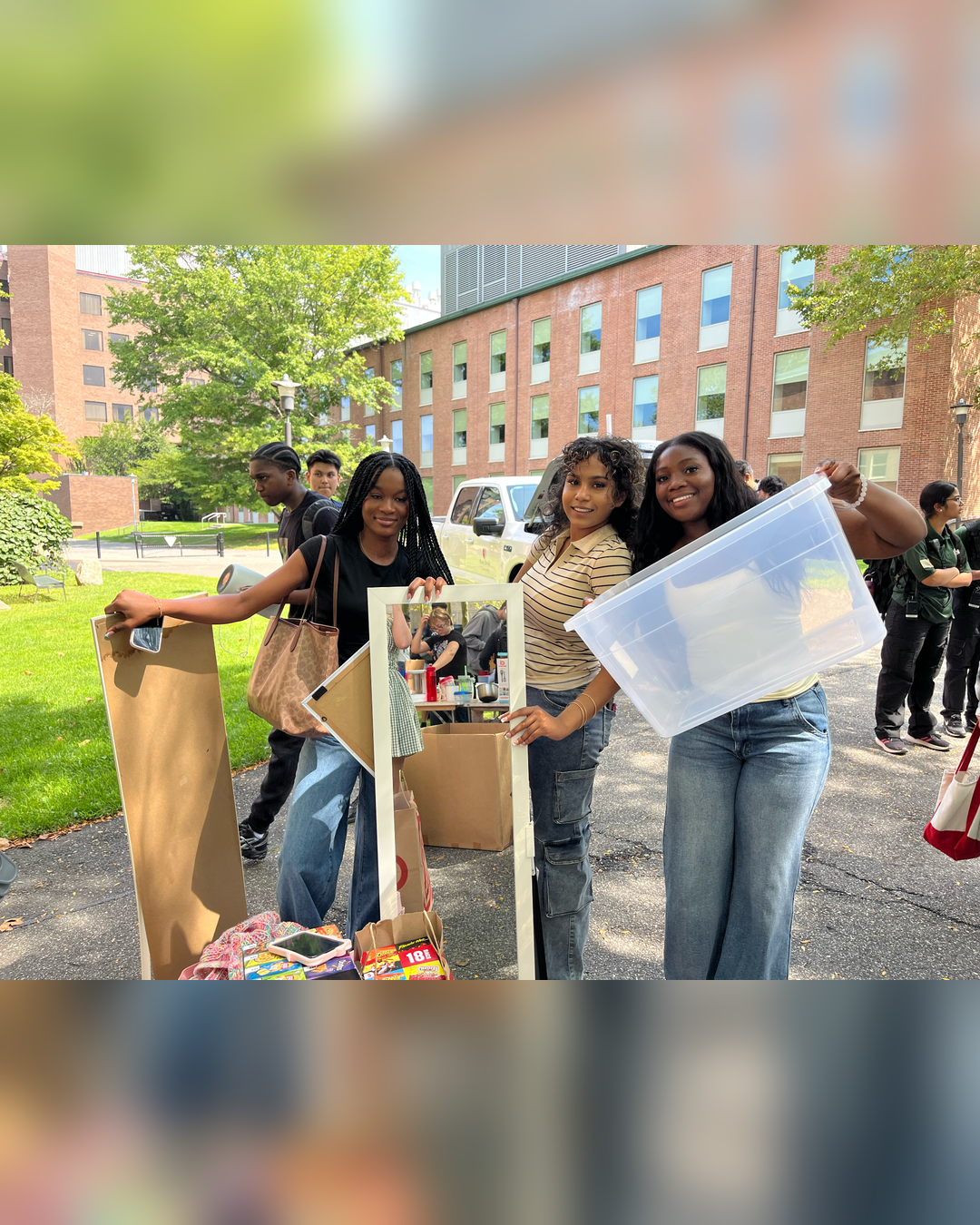 students holding recycling dorm room items