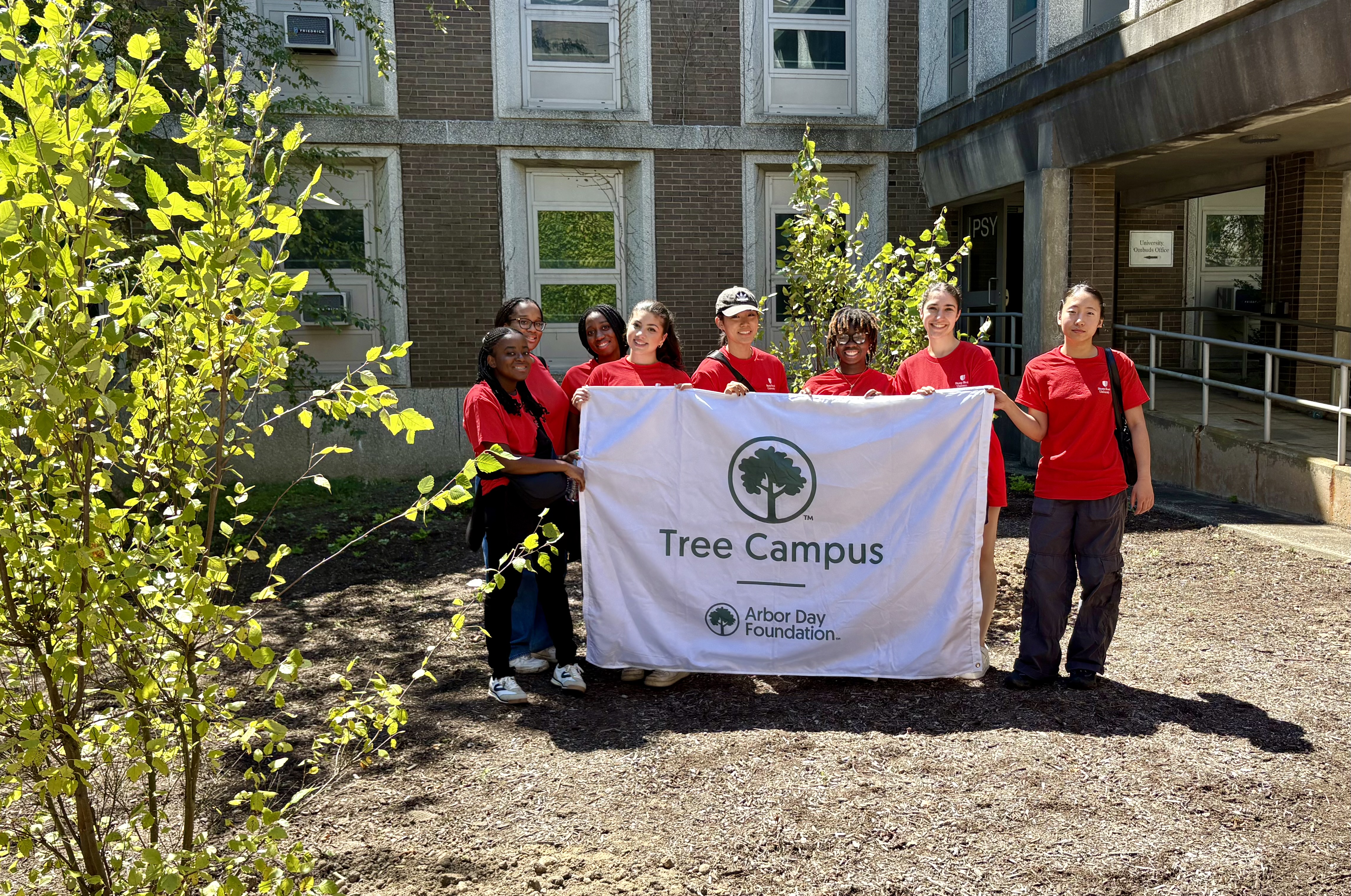 group of students hold "tree campus" sign