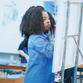 A student painting on a canvas