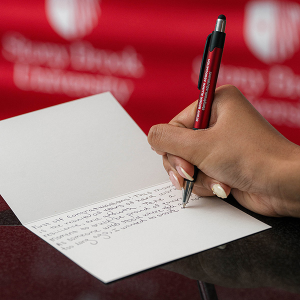 Female with pen in hand writing a note