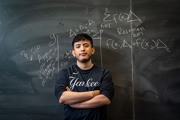 Student standing by chalkboard.