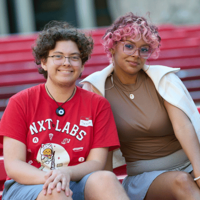 Two students sitting on steps for a photo
