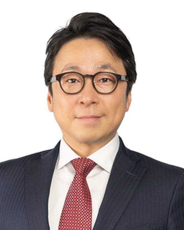 Tokufumi "Fumi" Kato Professional portrait of an individual wearing glasses, a dark suit, and a red patterned tie.