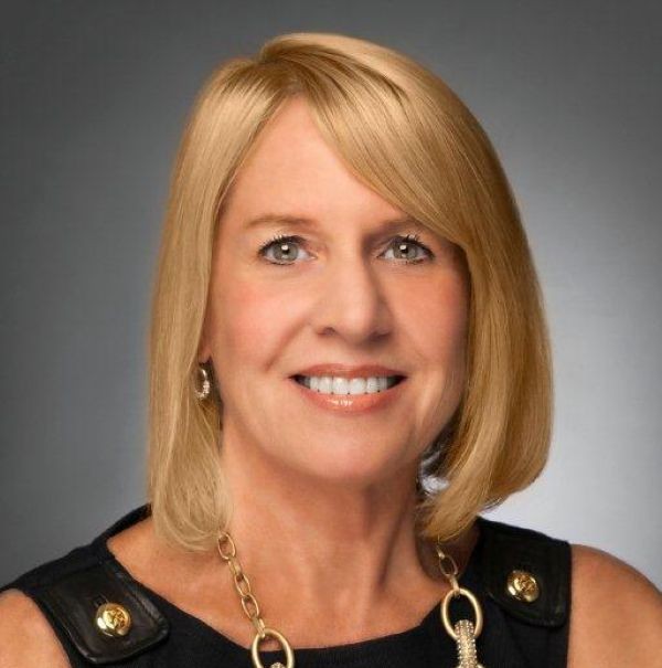 Susan Palmer Blonde female wearing a black suit posing in front of grey background