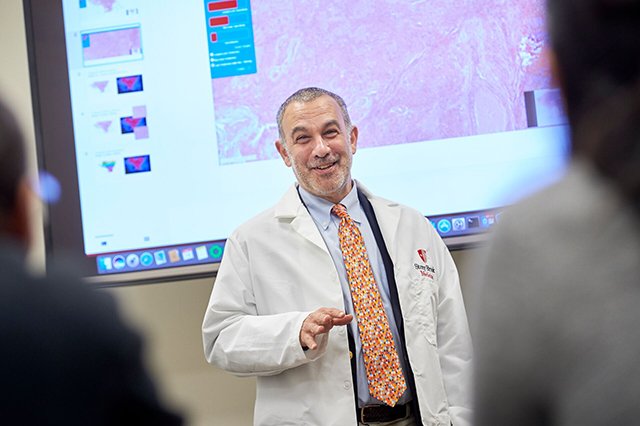 Biomedical Informatics Faculty Dr. Joel Saltz teaching in front of a slide