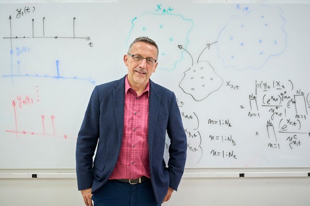 Electrical Engineering Faculty Professor Peter Djuric standing in front of the classroom, smiling, with hands in his pockets