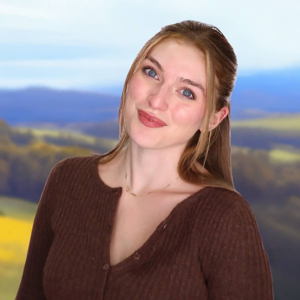 Julia Heming smiling in front of an outdoor landscape scene