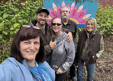 Volunteers pose for a photo in a community garden.