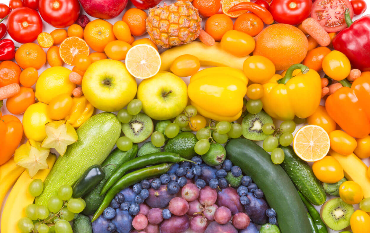 An assortment of colorful fruits and vegetables arranged in a rainbow pattern