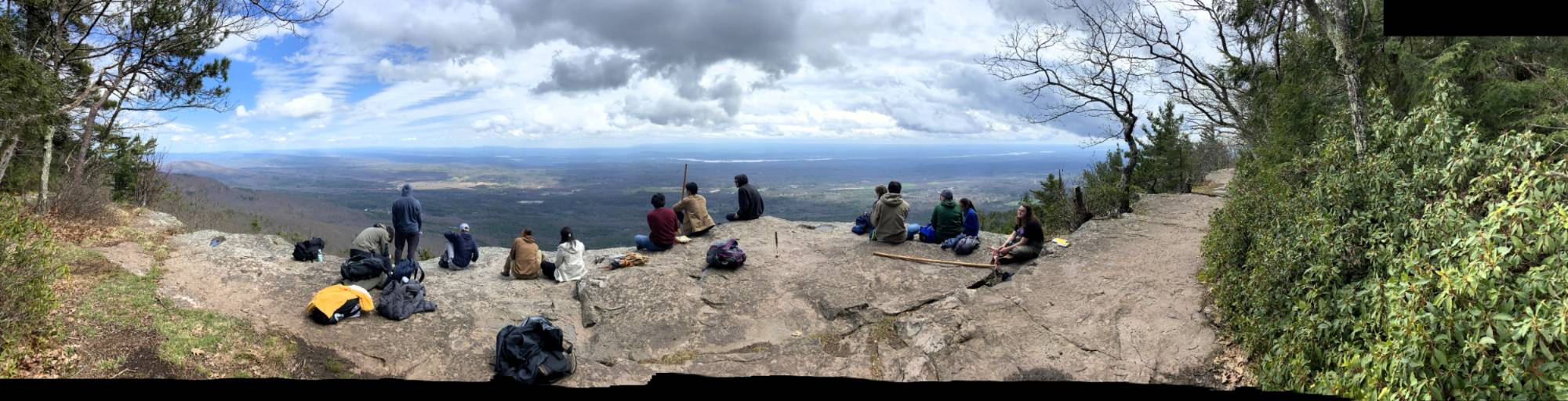 Students sitting on rocks looking out over valley