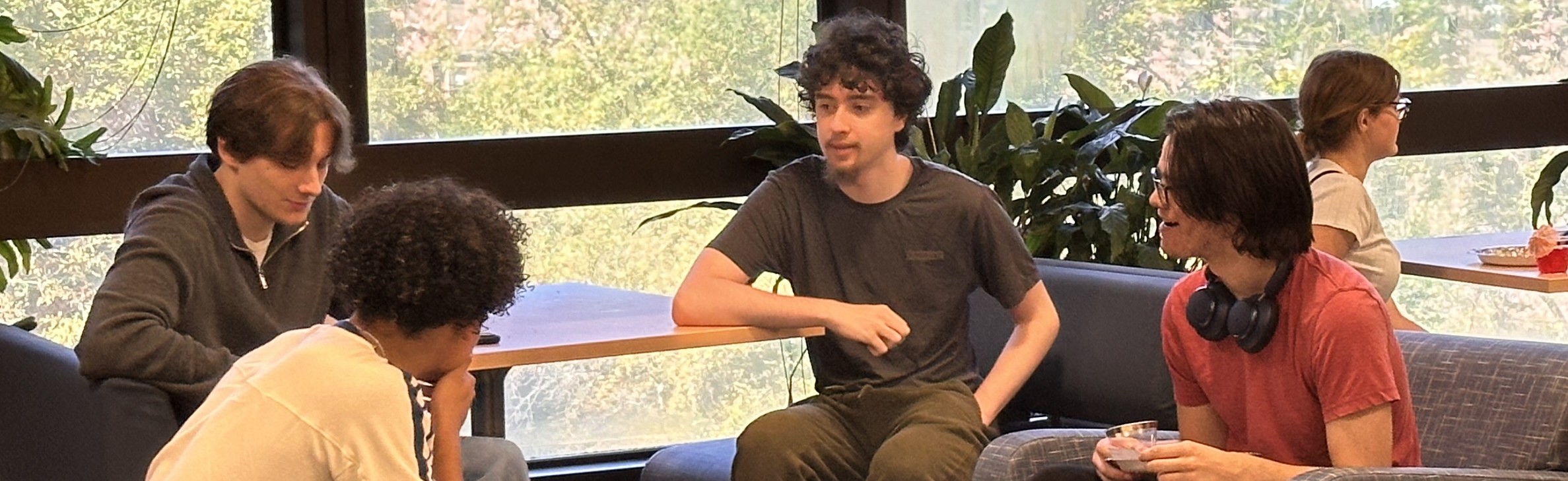 Students sitting around a tables teaching with a whiteboard