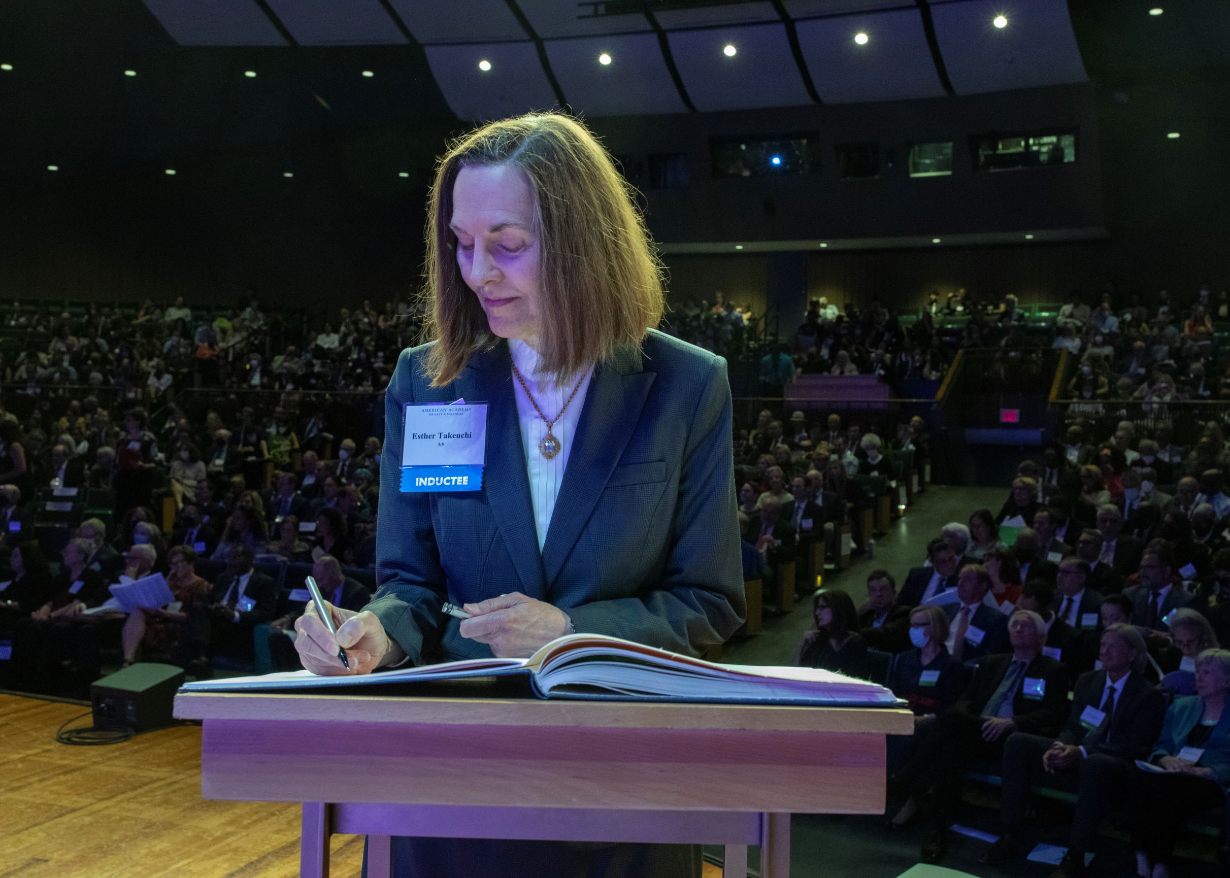 Dr. Esther Takeuchi signing a book