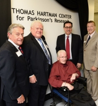 Group of people in front of sign dedicating the Thomas Hartman Center for Parkinson's Research