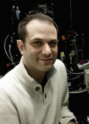 Headshot of Joshua Plotkin in front of microscope