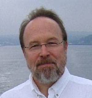 Headshot of William Collins with water in the background