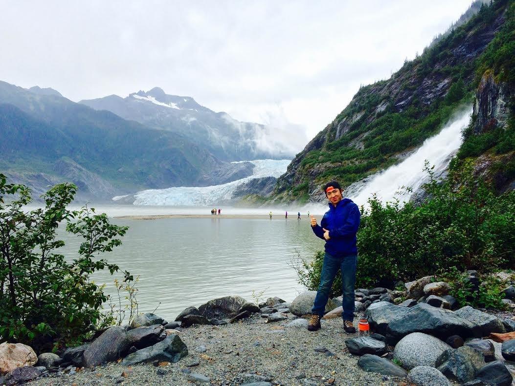 Student in Alaska by waterfall and glacier