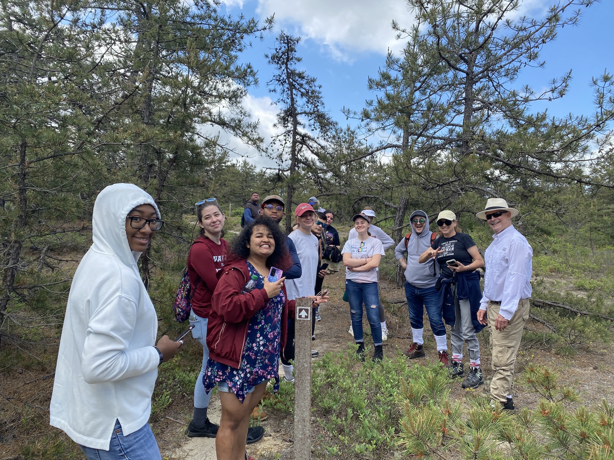 Students on a outdoor field trip hiking in a pine forest.