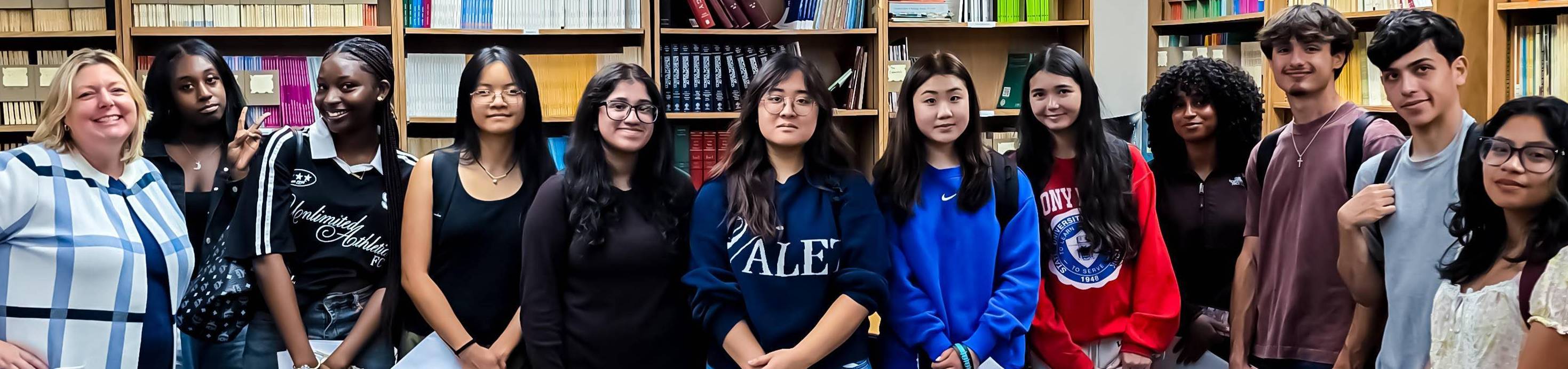 Students standing in the library posing for the picture