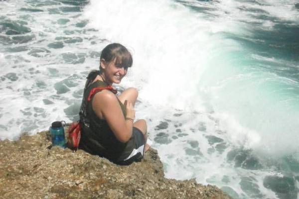 Celeste Stout sits at the shoreine while the waves crash Celeste Stout sits at the shoreine while the waves crash