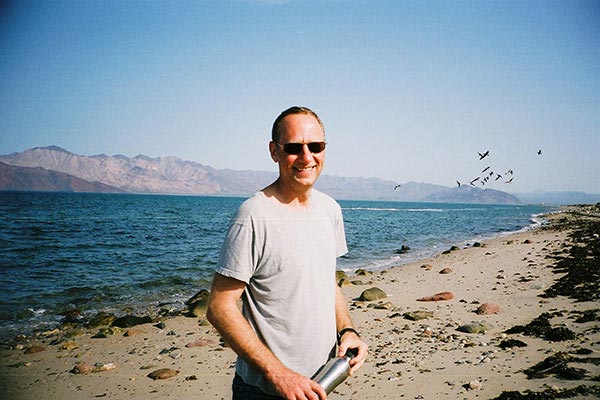 Kenneth Lang holds a water bottle at the beach Kenneth Lang holds a water bottle at the beach