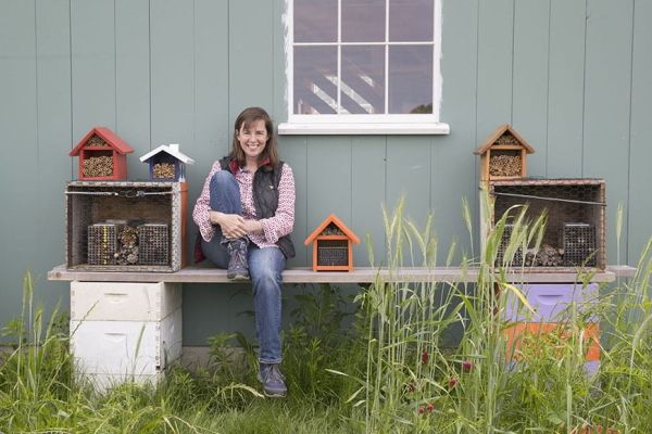 Laura Klahre sits on a bench against a barn Laura Klahre sits on a bench against a barn