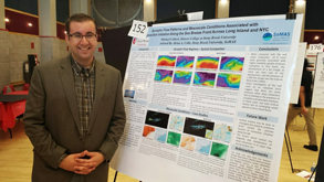 Michael Colbert stands next to his poster at URECA Michael Colbert stands next to his poster at URECA