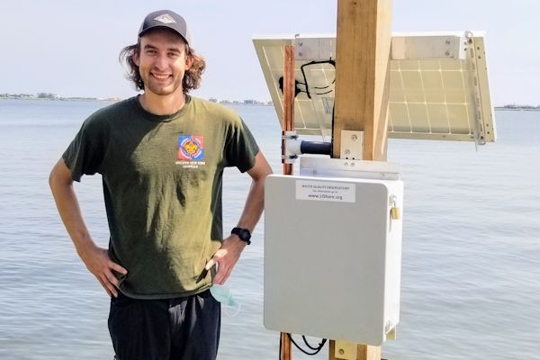 Miles Litzmann stands in front of an LI Shore observatory station