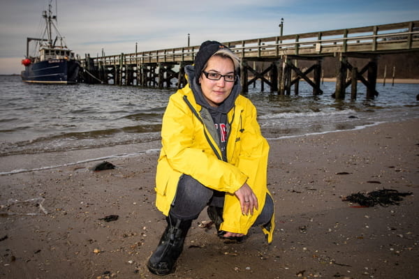 Sara Cernadas-Martín at the beach in Port Jefferson, NY in front of the Research Vessel Seawolf
