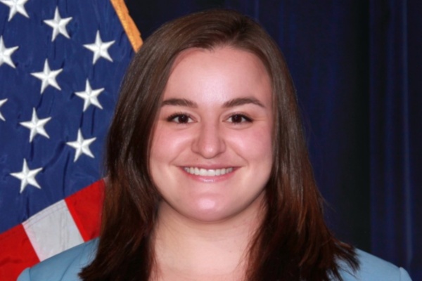 Taylor Apter stands in front of a US flag Taylor Apter stands in front of a US flag